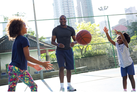 Healthy family playing basketball