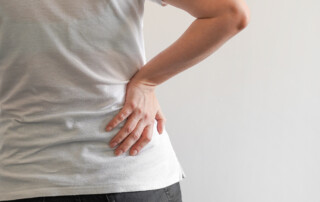 back of woman with hand on hip in pain
